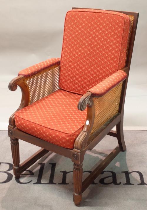 A late Regency mahogany chair, with cane panel back, sides and seat, having scroll arms, on turned and reeded legs, 52cm wide x 105cm high.