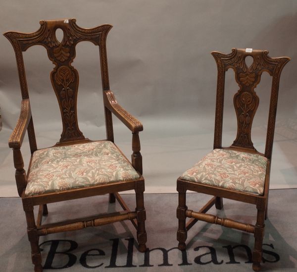 A set of twelve carved oak dining chairs, with foliate carved solid vase splat backs, drop in seats, on cylindrical and square section legs united by...