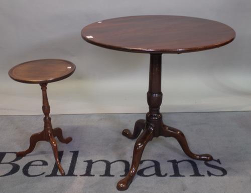 A George III mahogany tripod table on turned column and downswept supports, 69cm diameter x 70cm high, and a smaller later mahogany wine table with...