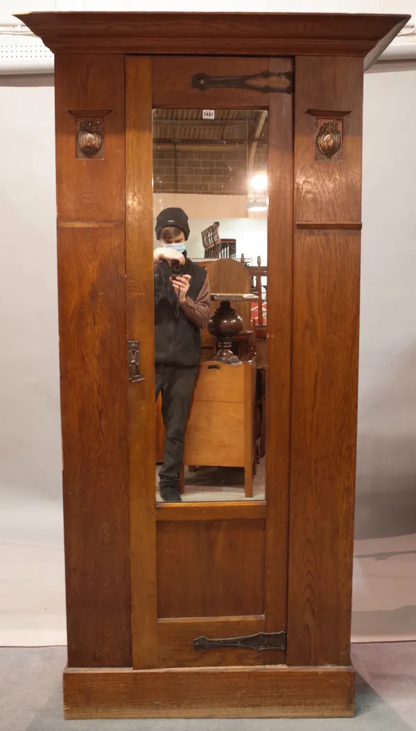An early 20th century oak Art Nouveau single wardrobe with central mirrored door on plinth base, 103cm wide x 199cm high.