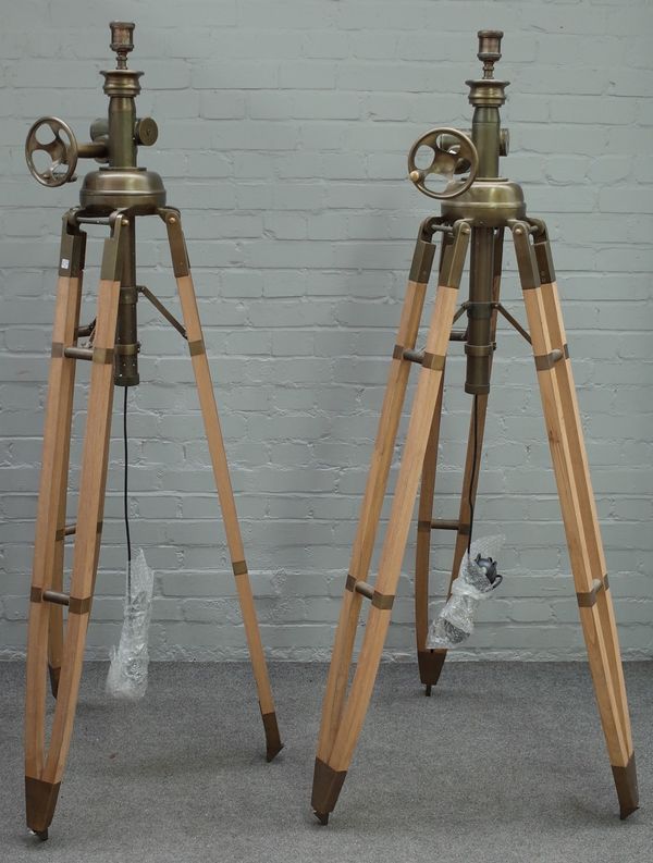 A pair of modern beech and brass height adjustable tripod standard lamps, 193cm high fully extended.