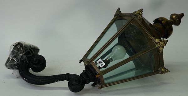 A Victorian hexagonal brass lantern, with glazed sides, supported on a scrolling wall bracket, 80cm high.