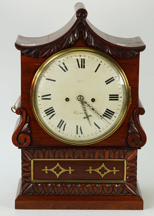 A late Regency rosewood bracket clock, of shaped outline, inlaid with cut-brass and leaf and scroll carved, indistinctly signed to the dial '........