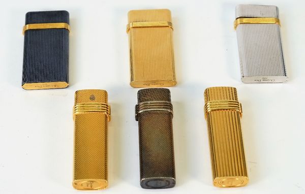 A collection of six Christian Dior lighters, all engine turned, four with a ribbed design, (6)