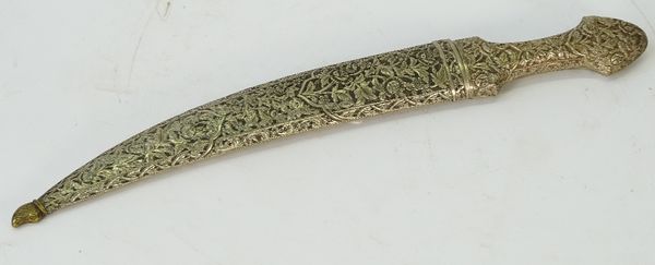 An Ottoman Turkish jambiya, mid-19th century, the hilt and scabbard encased in white metal with foliated chased decoration, the blade partly gilt...