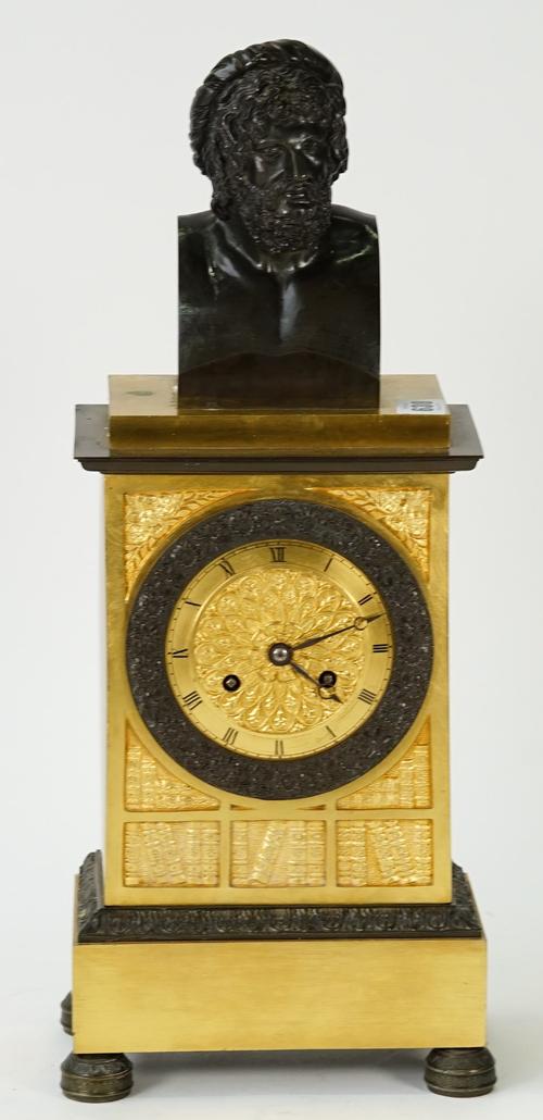 A Louis Philippe ormolu and bronze mantel clock, surmounted by a male bust on a stepped pediment above, 4 in., circular dial with relief cast panels...