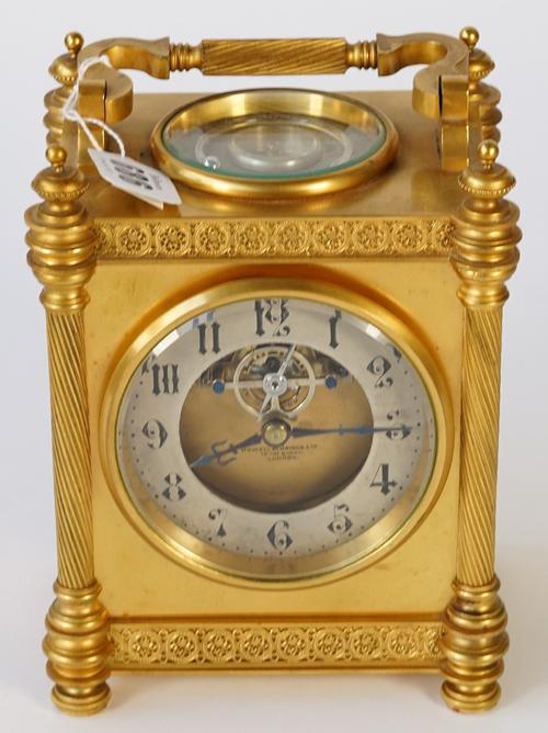 A French gilt brass carriage clock, the dial with silvered chapter ring and visible escapement detailed 'Howell & James Ltd', the top plate with...
