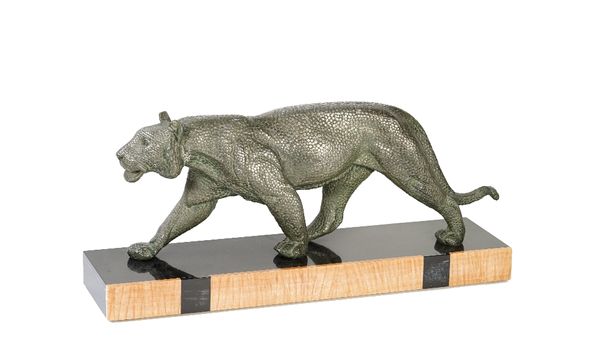 An Art Deco patinated spelter sculpture of a lioness, mounted on a rectangular marble base, inscribed 'RULAS', 57cm wide.