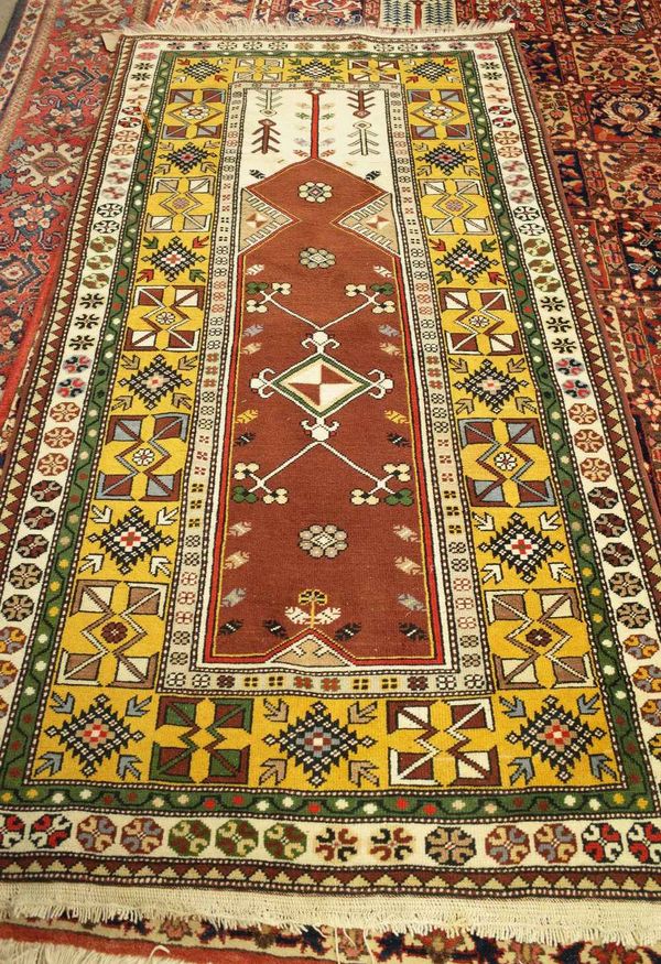 A Turkish prayer rug, the brown mehrab with a diamond to centre, ivory arch; a saffron diamond and arrow motif border, 210cm x 110cm.