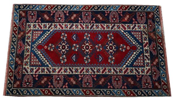 A Yagcibedir Turkish rug, the madder field with three flowerheads, an indigo stylised palmette and vine border, 197cm x 117cm, and a small Turkish...