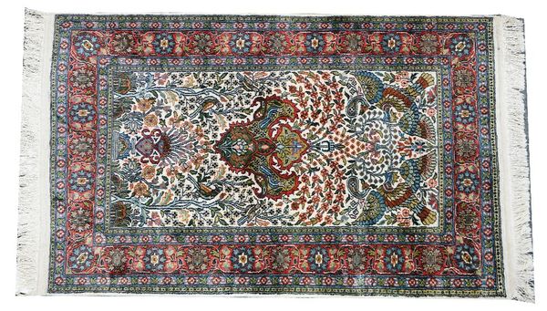 An Indian silk rug, the indigo field with a vase rising to two flying birds, floral sprays, an indigo floral border, 124cm x 76cm.