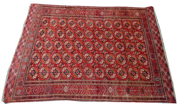 A Tekke Turkman carpet, the madder field with five columns of eleven guls, supporting medallions, a madder sunburst border with skirt ends, 296cm x...