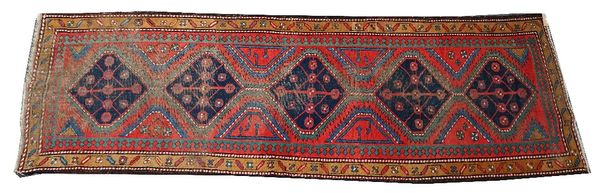 A Kazakh runner, Caucasian, the madder field with five indigo connecting medallions, a brown leaf and flower border, 334cm x 106cm.