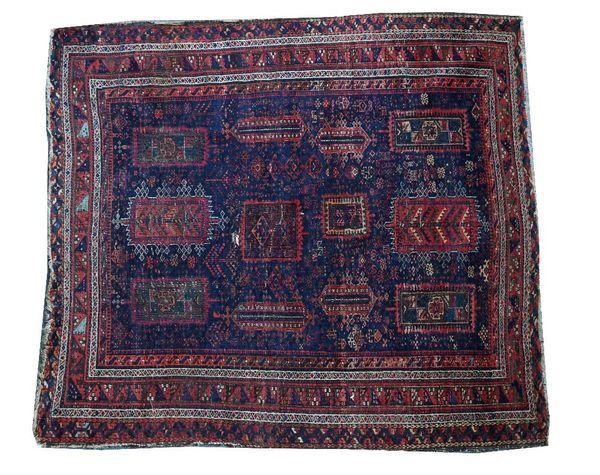 A Baluchistan rug, the indigo field with rectangular medallions, minor flowering plants; a border of triangles, 168cm x 157cm.