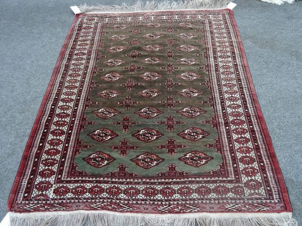 A Turkman rug, the washed sage field with three columns of nine guls; an ivory border, 205cm x 146cm.