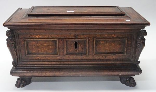 A 17th century Italian inlaid walnut cassone of small proportions with raised panel lid and triple panel front flanked by female busts resting on paw...