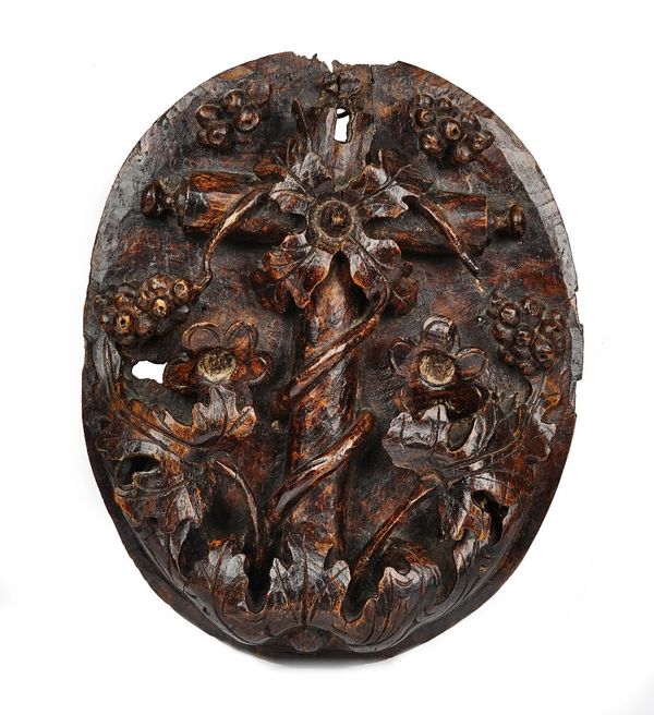 A 17th century Italian walnut oval panel relief carved with a fruiting vine, the gilt back with old lock recesses 28cm wide x 33cm high.