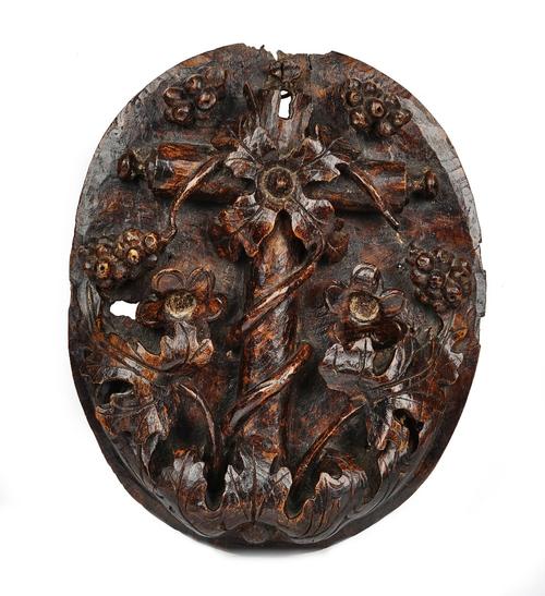 A 17th century Italian walnut oval panel relief carved with a fruiting vine, the gilt back with old lock recesses 28cm wide x 33cm high.