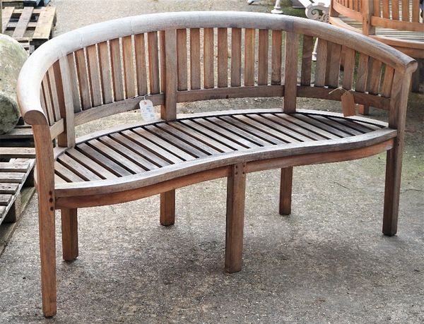 A teak framed semi-elliptic garden bench with slatted back and seat on block supports, 158cm wide x 85cm high.