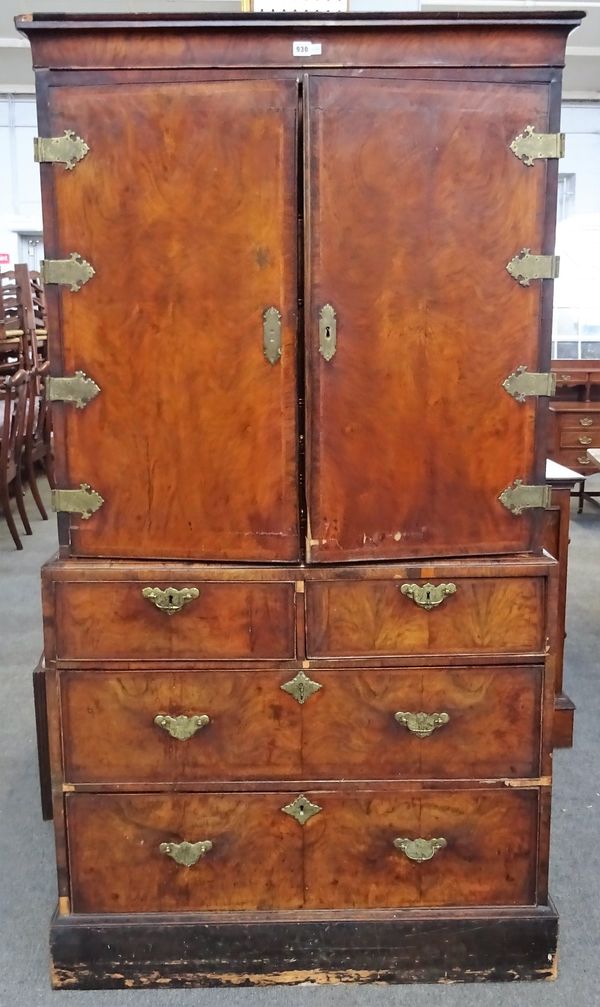 A George I and later featherbanded walnut cabinet on chest, the pair of doors enclosing ten various small drawers, the base with two short and two...