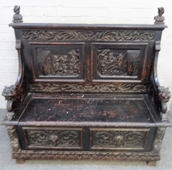 A late 19th century carved oak box seat settle, with recumbent beast arm supports, 120cm wide x 117cm high.