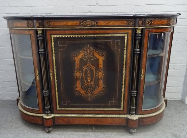 A Victorian figured walnut, ebonised and gilt metal mounted credenza, the central cupboard flanked by pair of rounded glazed doors, on plinth and bun...