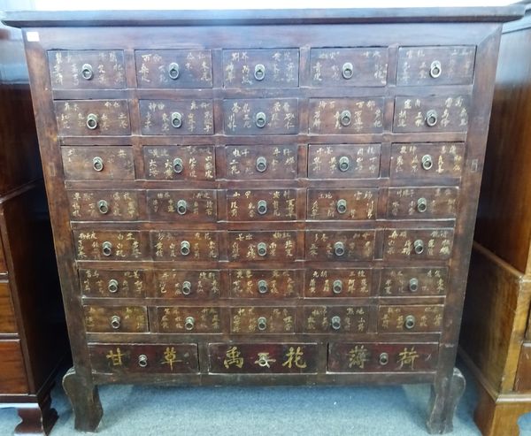 A Chinese hardwood apothecary chest with seven rows of five short drawers, polychrome painted with Chinese text, 150cm wide x 151cm high.