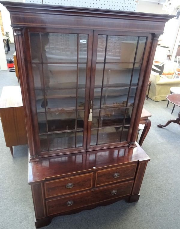 A George III inlaid mahogany display cabinet chest, the pair of glazed doors over two short and one long drawer on shaped plinth base, 127cm wide x...