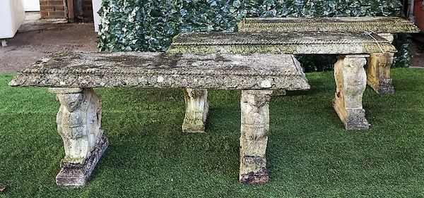 Three reconstituted stone garden benches, each on opposing beast moulded trestle end standards, 125cm wide x 48cm high, (3).