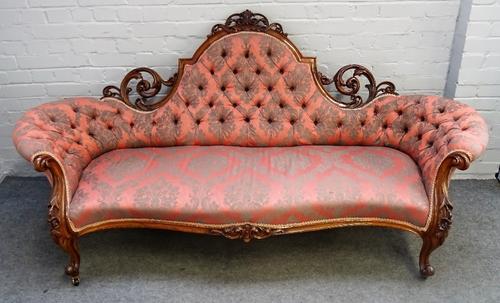 A Victorian carved and pierced walnut framed tub back sofa, with serpentine seat on scroll supports, 200cm wide x 97cm high.