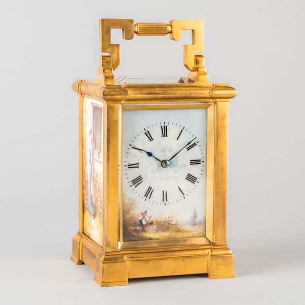 A FRENCH GILT BRASS AND PORCELAIN TRIPLE-PANELLED CARRIAGE TIMEPIECE