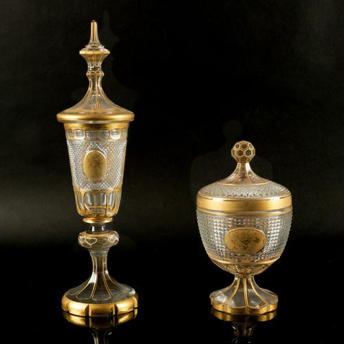 A BOHEMIAN TALL CUT GLASS AND PARCEL-GILT GOBLET AND COVER AND SIMILAR URN AND COVER (4)