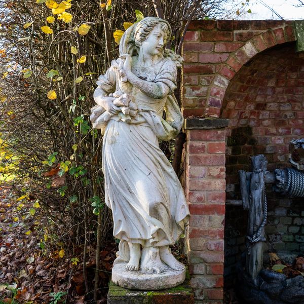 A RECONSTITUTED STONE FIGURE OF A FEMALE WOOD GATHERER