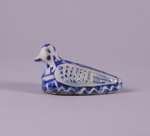 A PERSIAN POTTERY BLUE AND WHITE RATTLE IN THE FORM OF A BIRD