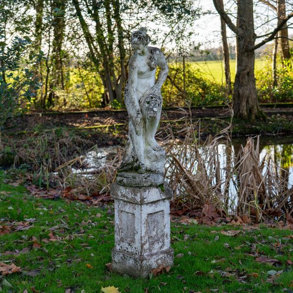 A RECONSTITUTED STONE FIGURE OF A BATHING WOMAN