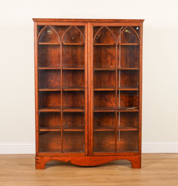 A GOTHIC REVIVAL STAINED PINE GLAZED TWO DOOR BOOKCASE