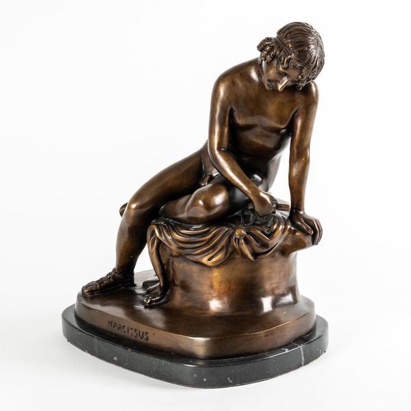 A BRONZE EFFECT CAST METAL FIGURE OF A NARCISSUS LOOKING INTO THE POOL