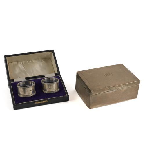 A SILVER TABLE CIGARETTE BOX AND A PAIR OF SILVER NAPKIN RINGS (4)