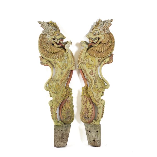 A PAIR OF SOUTH EAST ASIAN POLYCHROME DECORATED CARVED HARDWOOD LION RAMPANT NEWELL POSTS  OR FINIALS (2)