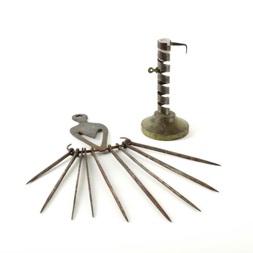 A FRENCH WROUGHT IRON 'RAT DE CAVE' EJECTOR CANDLESTICK TOGETHER WTH A WROUGHT IRON HANGER AND SKEWERS  (2)
