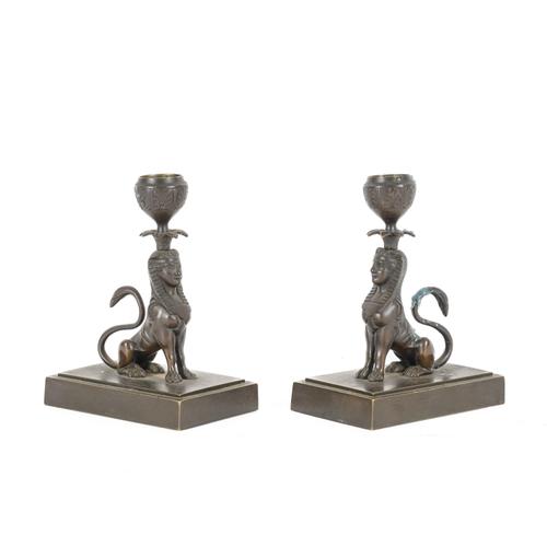 OF GRAND TOUR INTEREST: A PAIR OF EGYPTIAN REVIVAL PATINATED BRONZE SPHINX CANDLESTICKS AND A PAIR OF RELIEF CAST PORTRAIT MEDALLIONS OF ATHENA AND MARS (4)