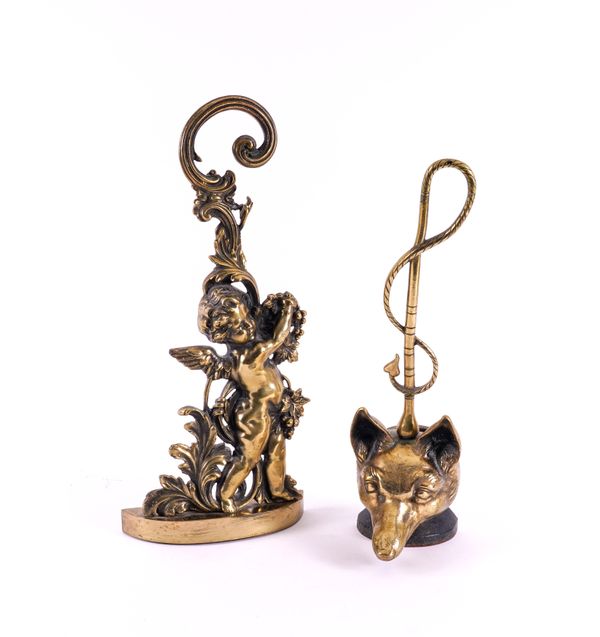 TWO ENGLISH PEERAGE BRASS DOOR STOPS: ONE MODELLED AS A BACCHANALIAN PUTTO, THE OTHER A FOX’S HEAD  (2)