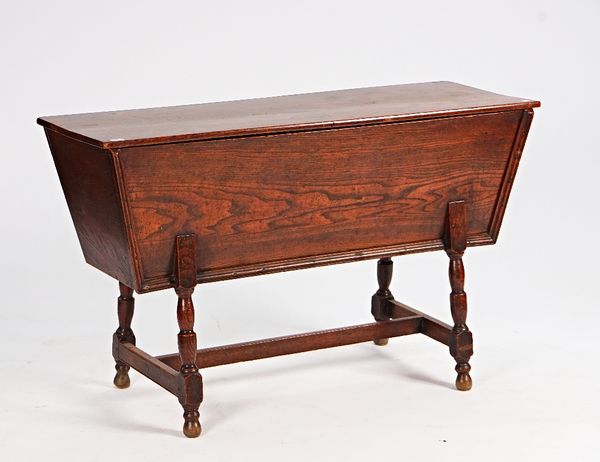 An 18th century elm sarcophagus formed dough bin on turned supports, 125cm wide x 76cm high.