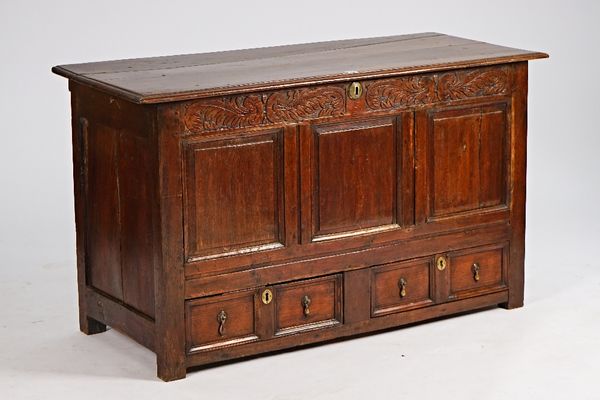 A 17th century oak mule chest the lift top over triple panel front and a pair of drawers, 134cm wide x 76cm high.