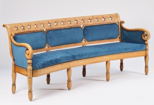 A Charles X bleached elm bow back sofa with star pierced crest rail and shepherd's crook arms on reverse tulip carved supports, 214cm wide x 86cm...