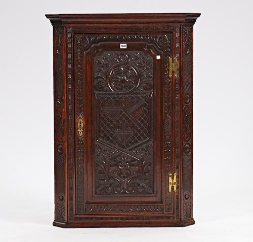 An 18th century oak and later carved corner cupboard with fitted interior, 78cm wide x 108cm high.