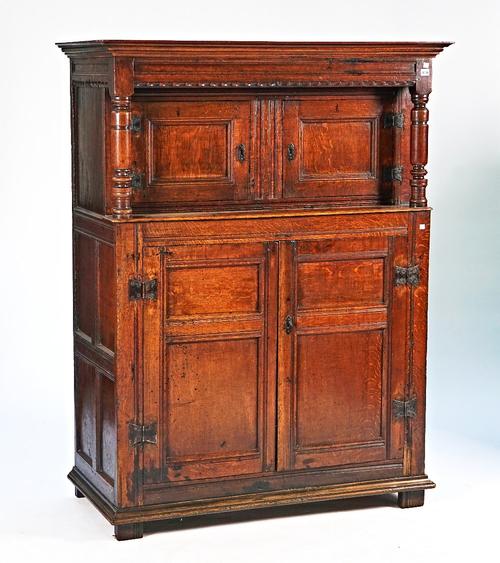 A 17th century oak court cupboard with two pairs of panelled doors and turned supports, 123cm wide x 161cm high.