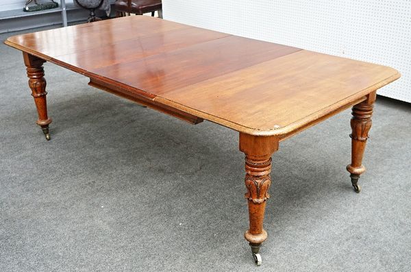 An early Victorian mahogany extending dining table, on lappet carved turned supports, with three extra leaves.