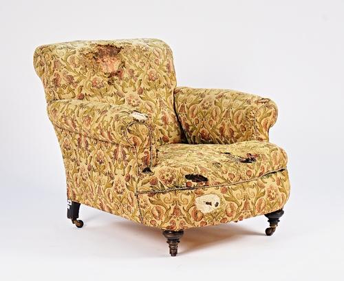 A Victorian easy armchair, in the manner of Howard & Sons, on turned ebonised supports, 90cm wide x 85cm high.