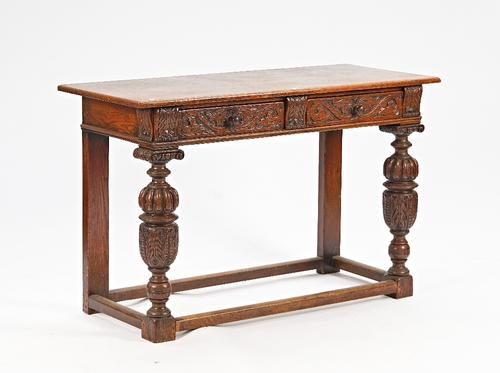 A 17th century style carved oak serving table, with pair of frieze drawers on cup and cover supports, united by perimeter stretcher, 130cm wide x...